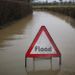 A-council-sign-sits-in-flood-water-on-a-road-near-Lingfield